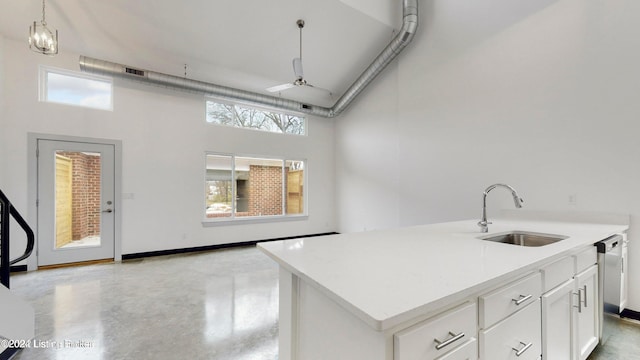 kitchen featuring white cabinetry, a center island with sink, ceiling fan, a wealth of natural light, and sink