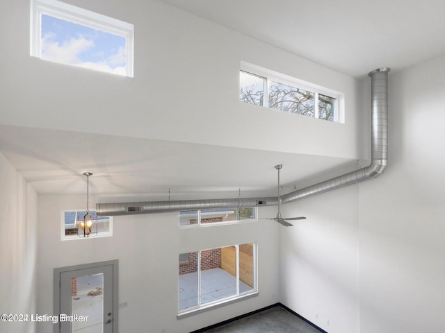 unfurnished living room featuring ceiling fan and a wealth of natural light