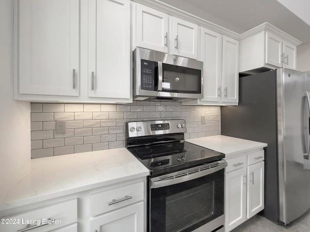 kitchen featuring decorative backsplash, white cabinets, and appliances with stainless steel finishes