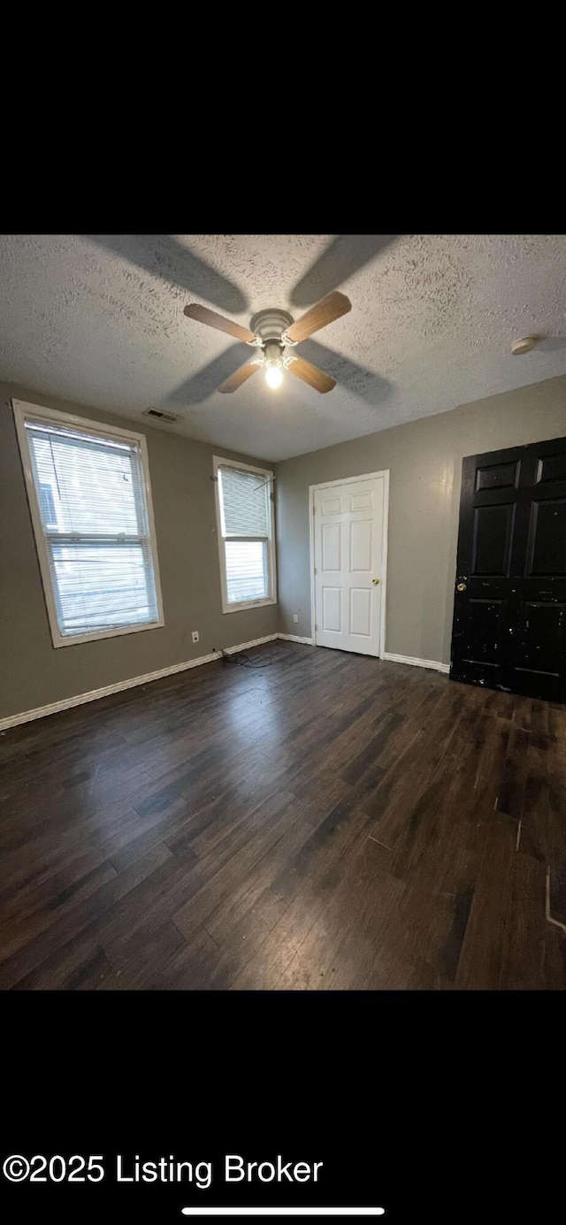 unfurnished bedroom featuring ceiling fan, dark hardwood / wood-style flooring, and multiple windows