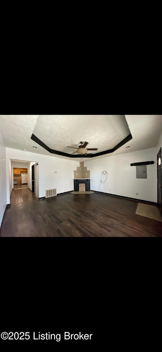 unfurnished living room featuring hardwood / wood-style floors and a raised ceiling