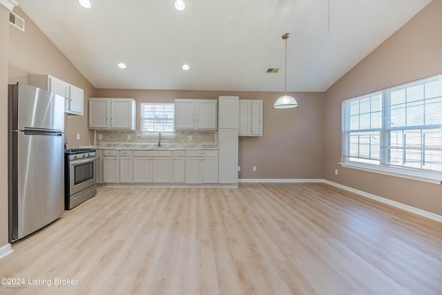 kitchen featuring white cabinetry, stainless steel appliances, decorative backsplash, light hardwood / wood-style floors, and hanging light fixtures