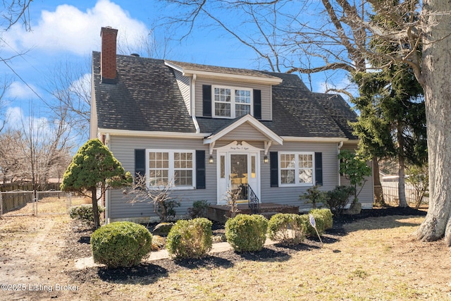 view of front of house with roof with shingles, fence, and a chimney