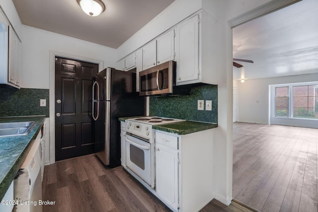 kitchen with dark wood-type flooring, sink, tasteful backsplash, appliances with stainless steel finishes, and white cabinets