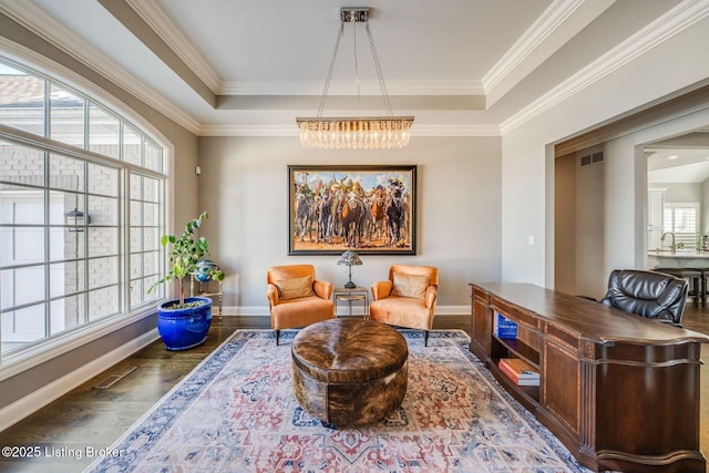 sitting room with ornamental molding, an inviting chandelier, dark hardwood / wood-style floors, and a raised ceiling