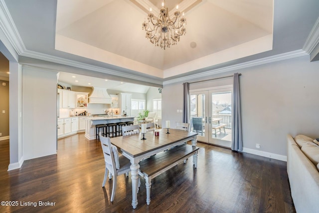 dining area with ornamental molding, french doors, dark wood-type flooring, and a raised ceiling