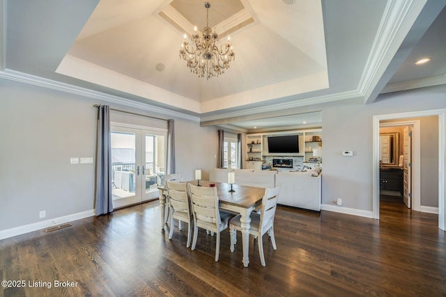 dining area featuring a tray ceiling, dark hardwood / wood-style flooring, crown molding, and french doors