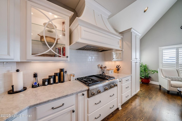 kitchen featuring white cabinetry, dark hardwood / wood-style flooring, premium range hood, vaulted ceiling, and stainless steel gas stovetop