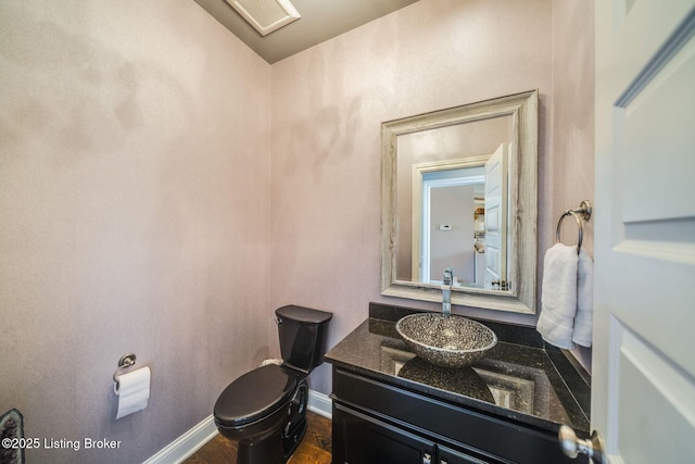 bathroom with hardwood / wood-style flooring, toilet, and vanity