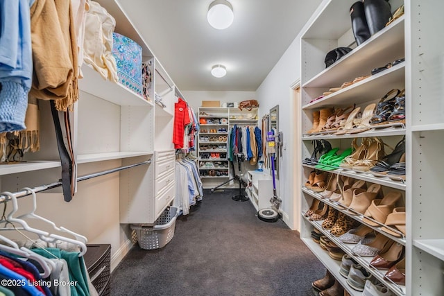 walk in closet with dark carpet