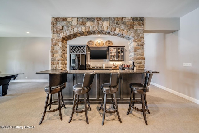 bar with black fridge and light carpet