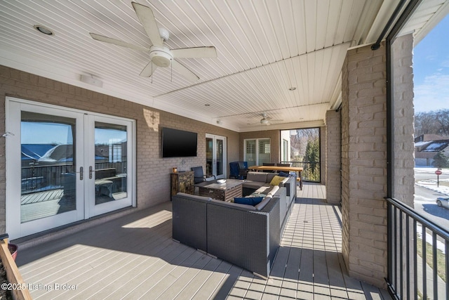 wooden deck featuring an outdoor living space, ceiling fan, and french doors