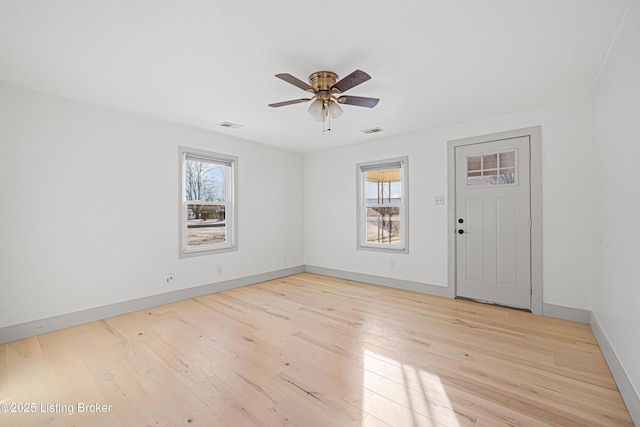 spare room with a healthy amount of sunlight, light hardwood / wood-style flooring, and ceiling fan