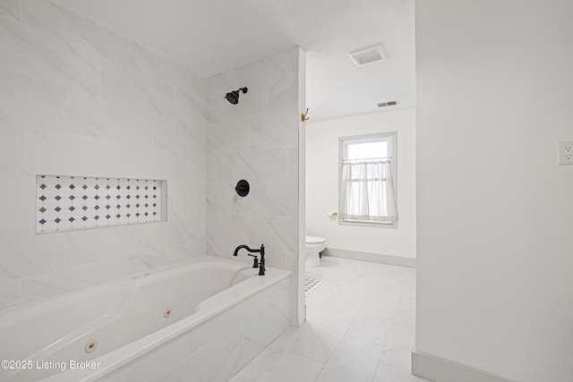 bathroom with toilet and tiled shower / bath