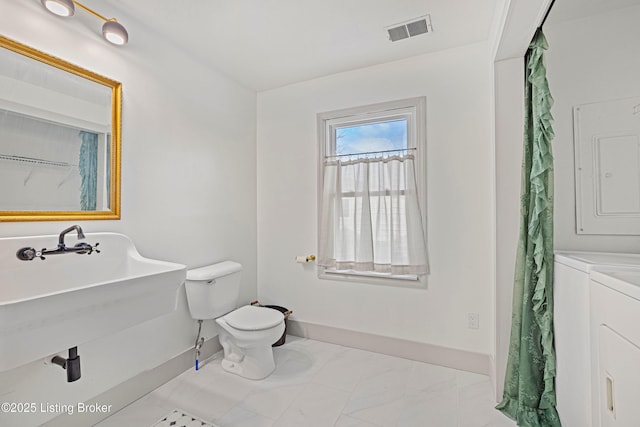 bathroom with toilet, electric panel, vanity, and independent washer and dryer