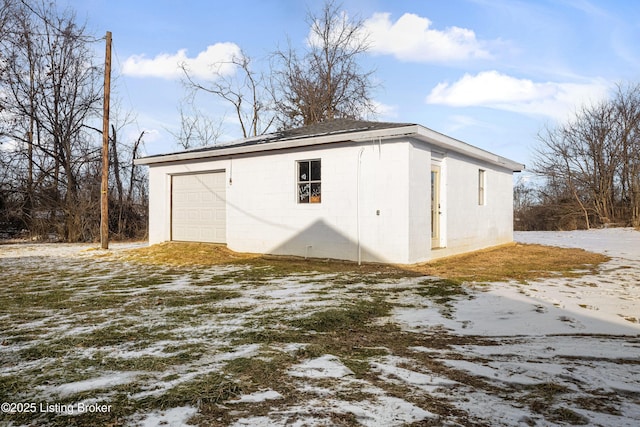 exterior space featuring a garage and an outbuilding