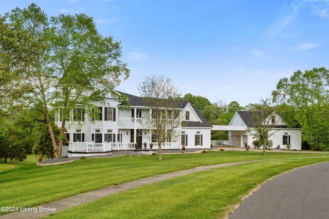 view of front of house with a front lawn, a balcony, and a garage