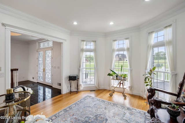 doorway with hardwood / wood-style flooring, crown molding, and french doors