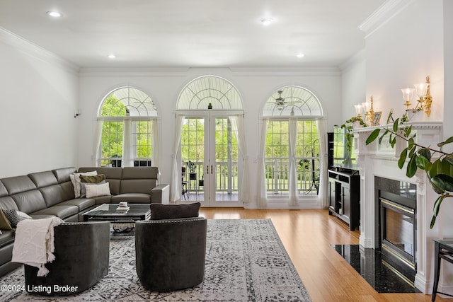 living room with light wood-type flooring, ornamental molding, and french doors