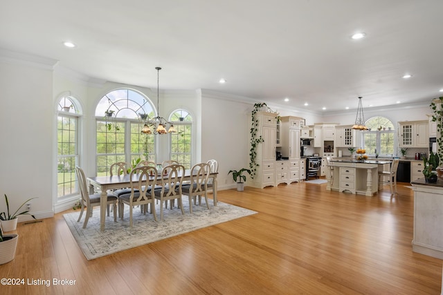 dining area with plenty of natural light, light hardwood / wood-style flooring, crown molding, and an inviting chandelier