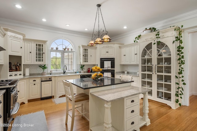 kitchen with black appliances, a kitchen island, decorative light fixtures, dark stone counters, and decorative backsplash