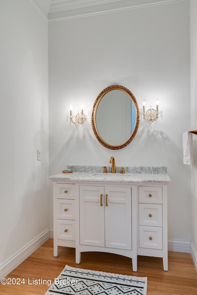 bathroom with hardwood / wood-style floors, vanity, and crown molding