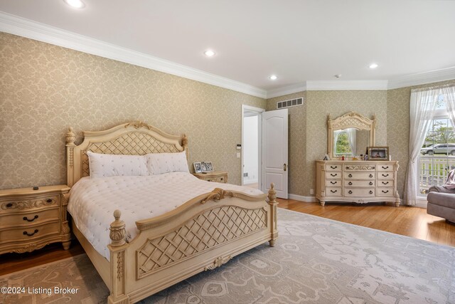 bedroom with crown molding and light hardwood / wood-style flooring