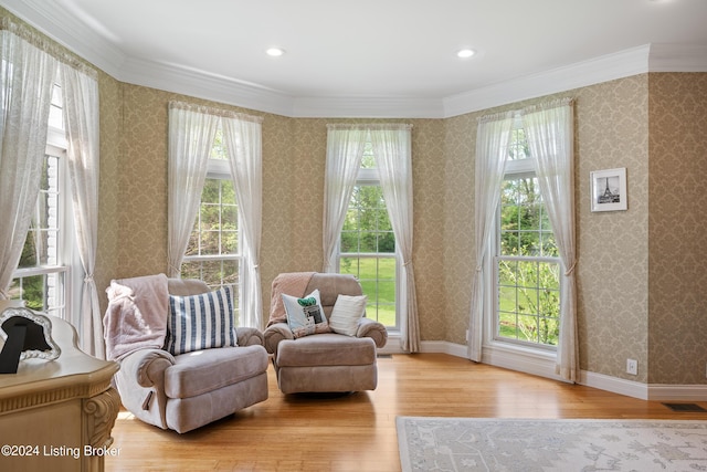 sitting room with light wood-type flooring and ornamental molding