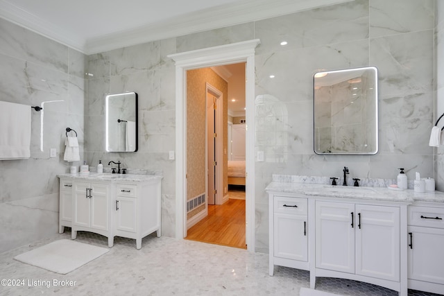 bathroom with tile walls, vanity, ornamental molding, and hardwood / wood-style floors