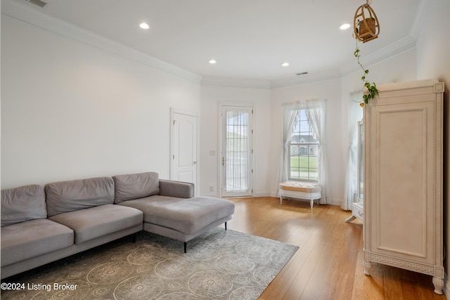 living room featuring light wood-type flooring and crown molding