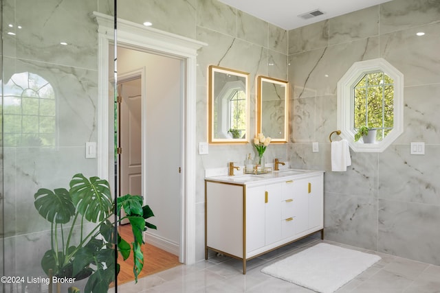 bathroom with tile patterned flooring, vanity, and tile walls