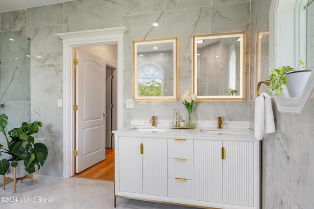 bathroom featuring vanity and tile walls