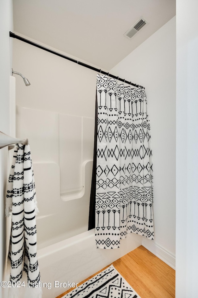 bathroom with wood-type flooring and walk in shower