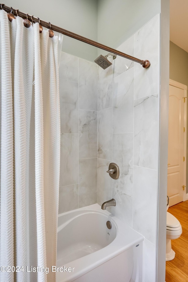 bathroom with shower / bath combination with curtain and wood-type flooring