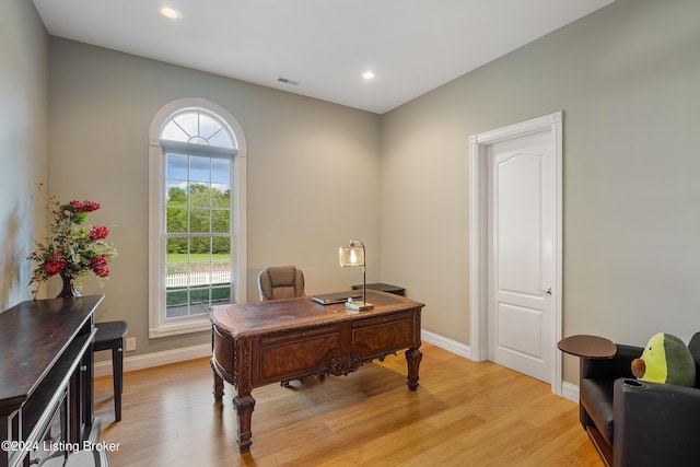 office with a healthy amount of sunlight and light hardwood / wood-style flooring