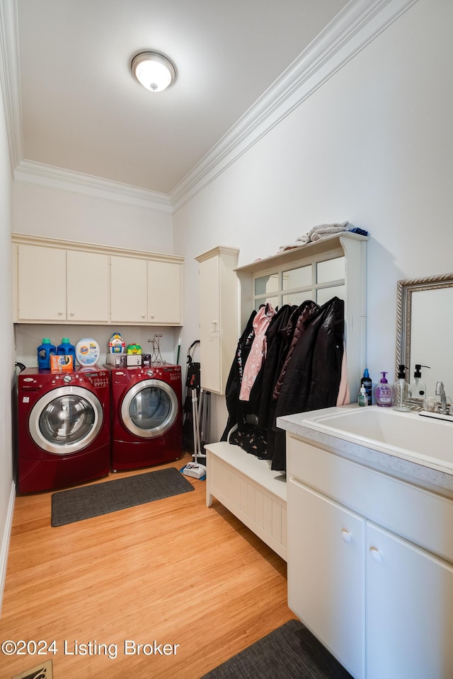 laundry room featuring cabinets, sink, independent washer and dryer, light wood-type flooring, and crown molding