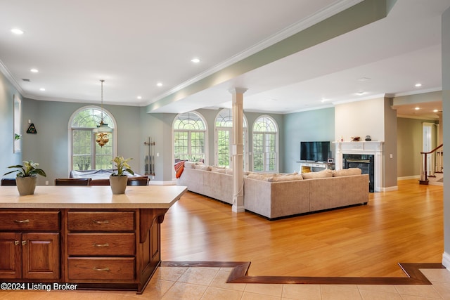 kitchen with hanging light fixtures, light tile patterned floors, a fireplace, and ornamental molding