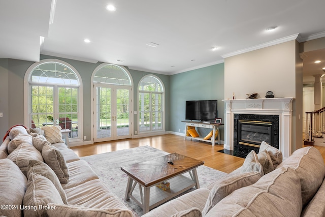 living room featuring a healthy amount of sunlight, crown molding, and light hardwood / wood-style flooring