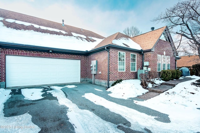 view of snowy exterior with a garage