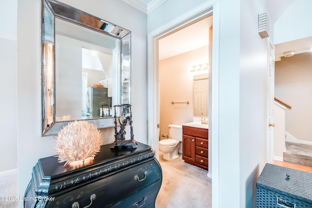 bathroom with vanity, toilet, and crown molding