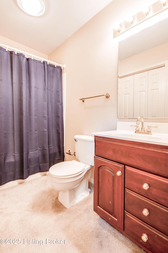 bathroom featuring vanity, toilet, and curtained shower