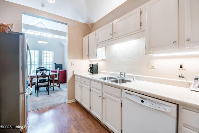 kitchen featuring hardwood / wood-style floors, white cabinetry, dishwasher, and stainless steel refrigerator