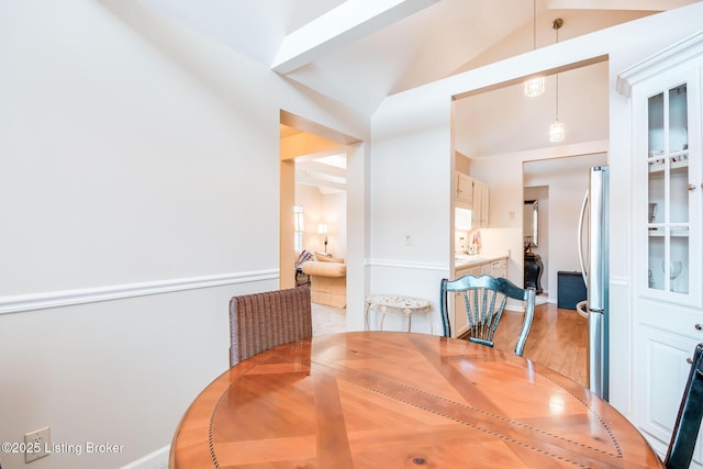 dining space with lofted ceiling with beams