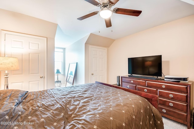 bedroom with light colored carpet, ceiling fan, and ensuite bathroom