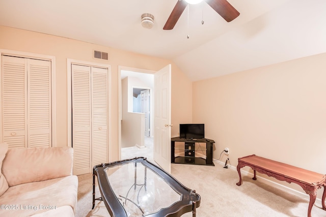 carpeted living room with ceiling fan and lofted ceiling