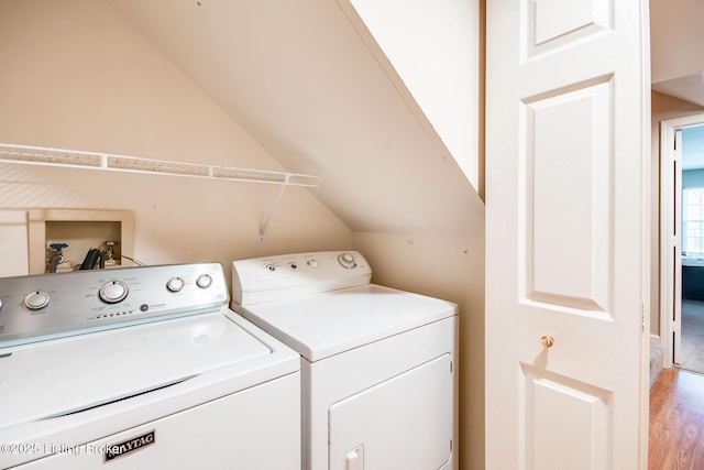 laundry room with light wood-type flooring and washer and clothes dryer