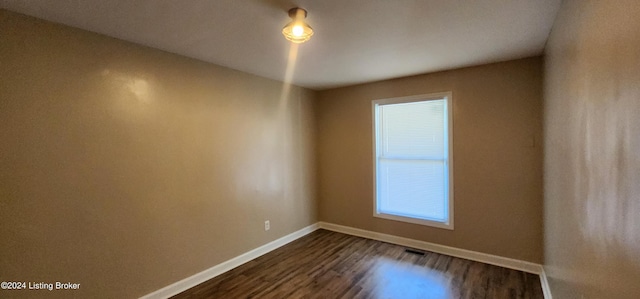 unfurnished room featuring dark wood-type flooring