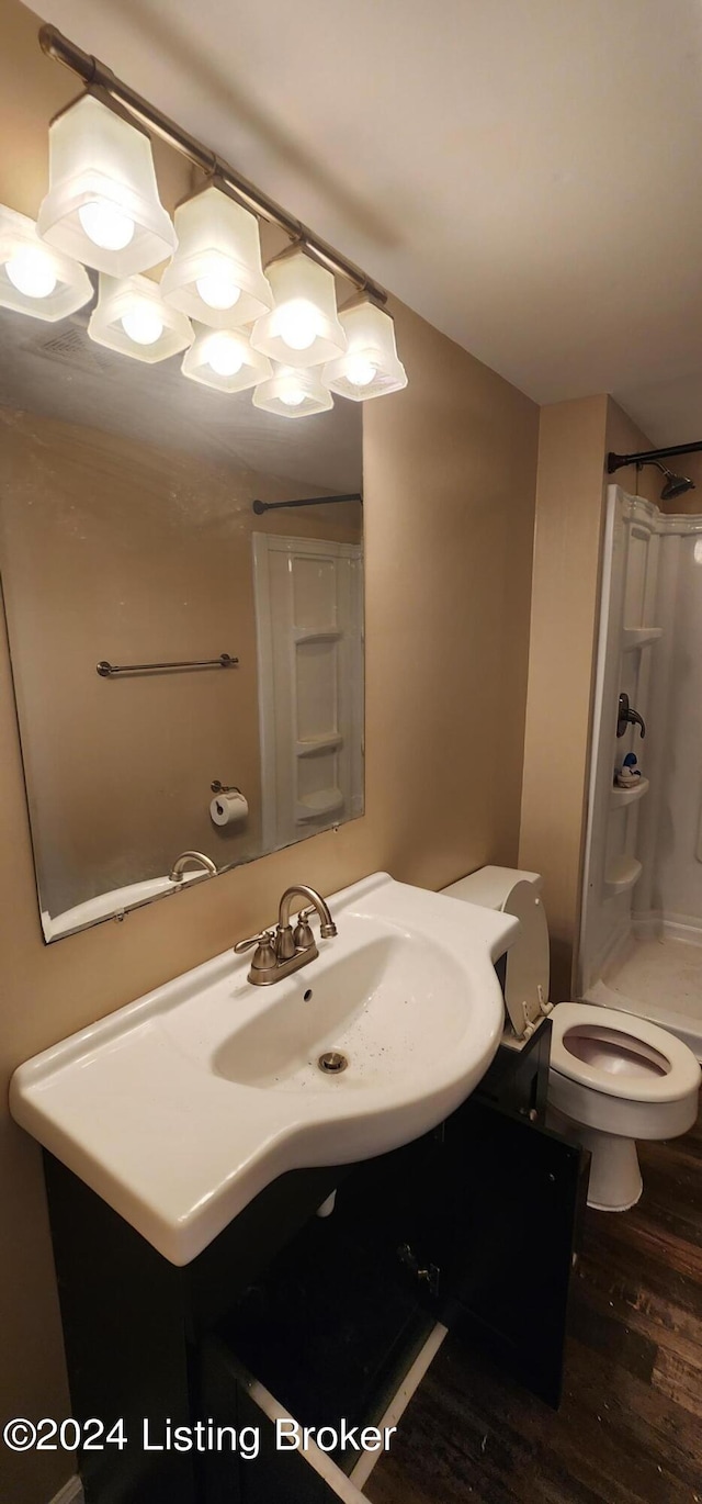 bathroom featuring hardwood / wood-style flooring, sink, toilet, and walk in shower