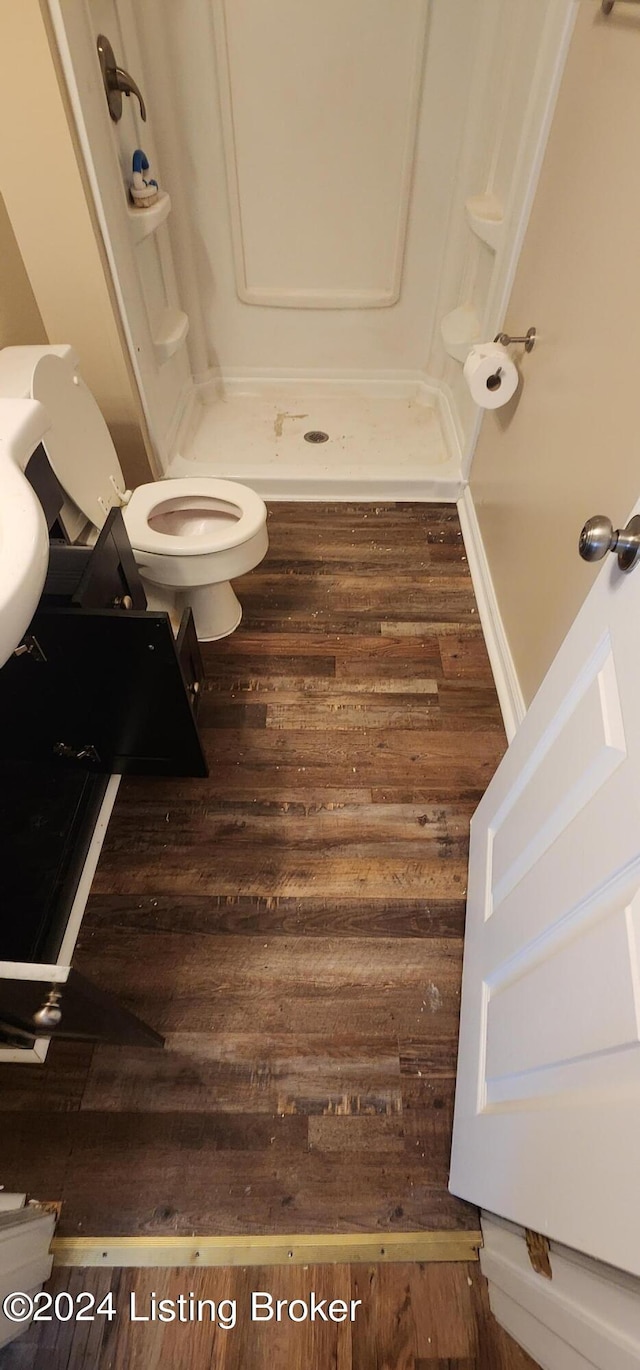 bathroom featuring toilet, wood-type flooring, and walk in shower