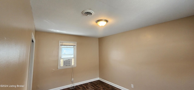 unfurnished room with cooling unit and dark hardwood / wood-style flooring